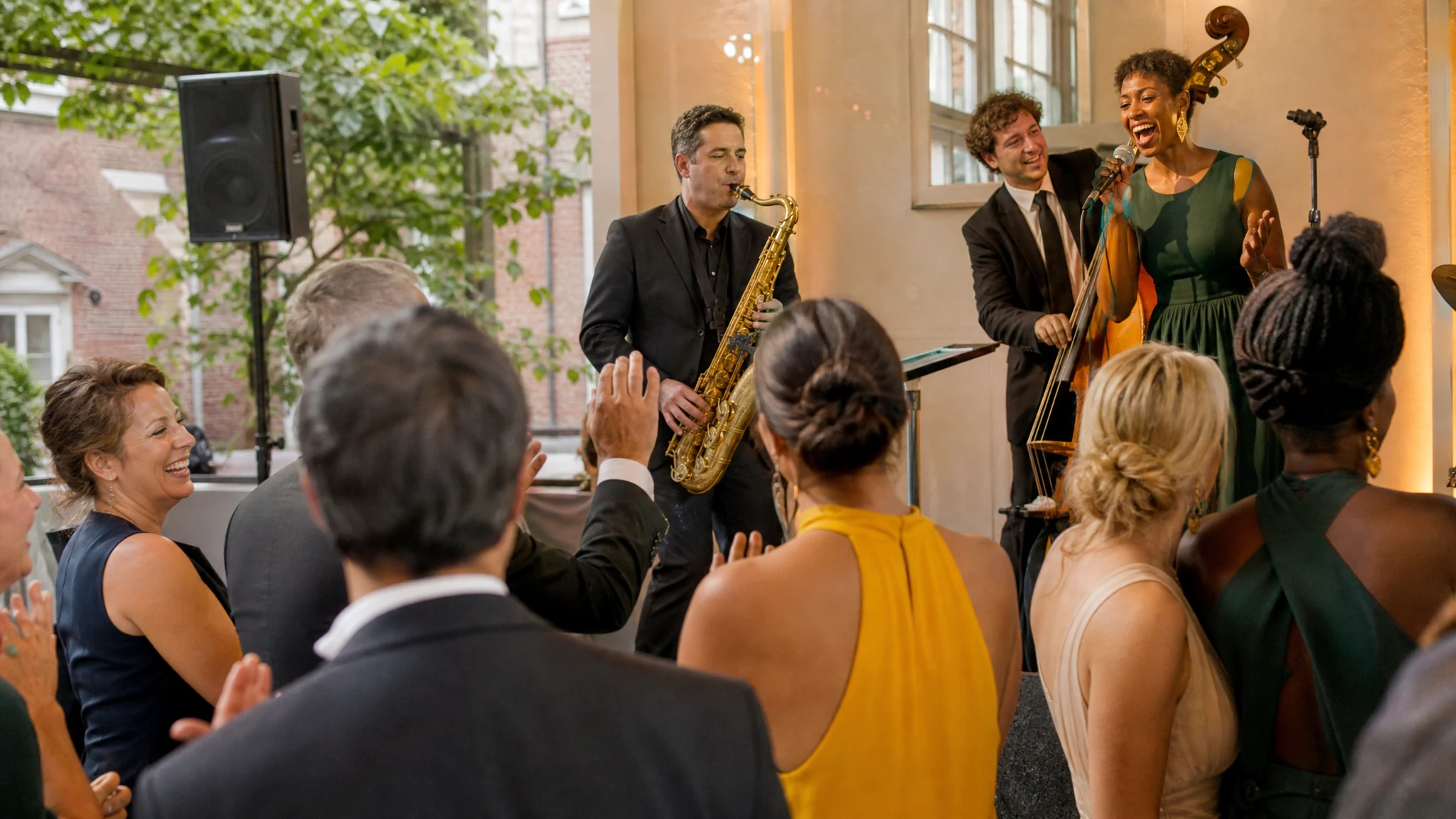 Eine Jazzband mit Saxofon, Kontrabass und Sängerin begeistert applaudierende Gäste bei einem Galaabend im Saal