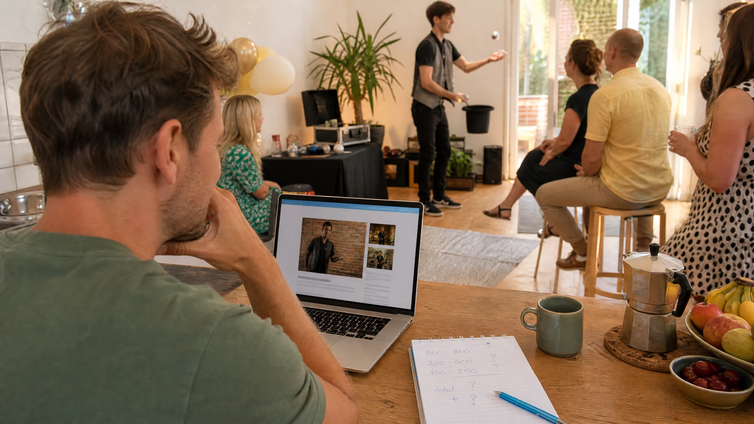 Ein Mann plant am Laptop, eine Showeinlage für einen Geburtstag in der Nähe zu buchen, hinter ihm tritt ein Zauberer auf